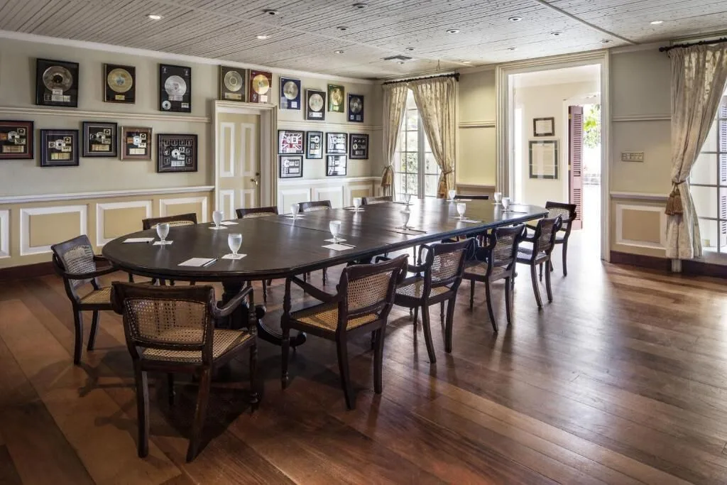 Conference room with long table, cane chairs and framed awards at Strawberry Hill.