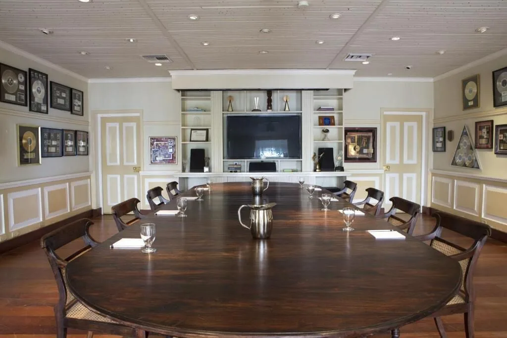 A long wooden conference table with framed records in a meeting room at Strawberry Hill.