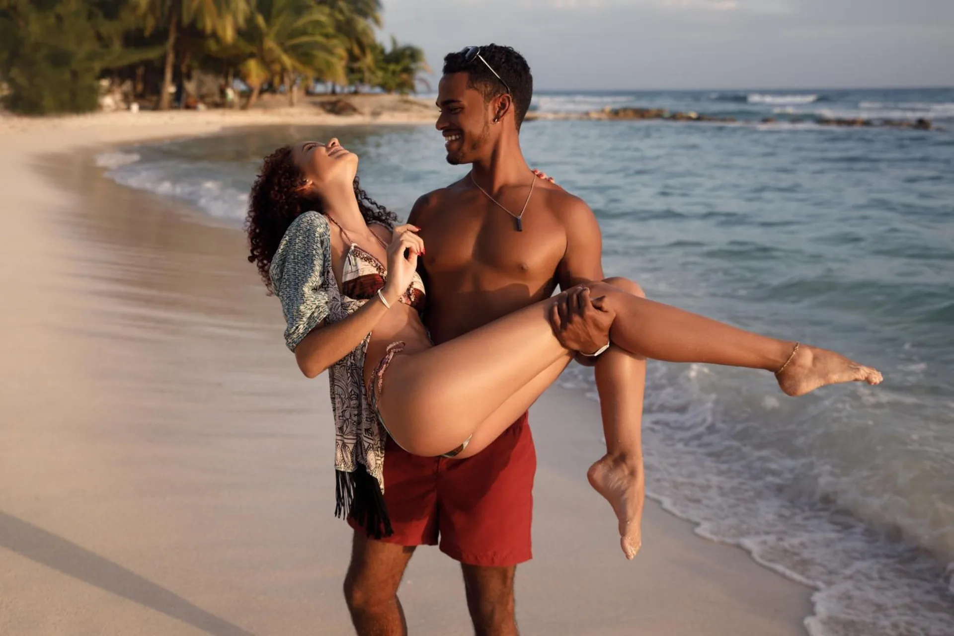 Couple laughing at the shoreline on the beach at Sugar Bay Barbados.
