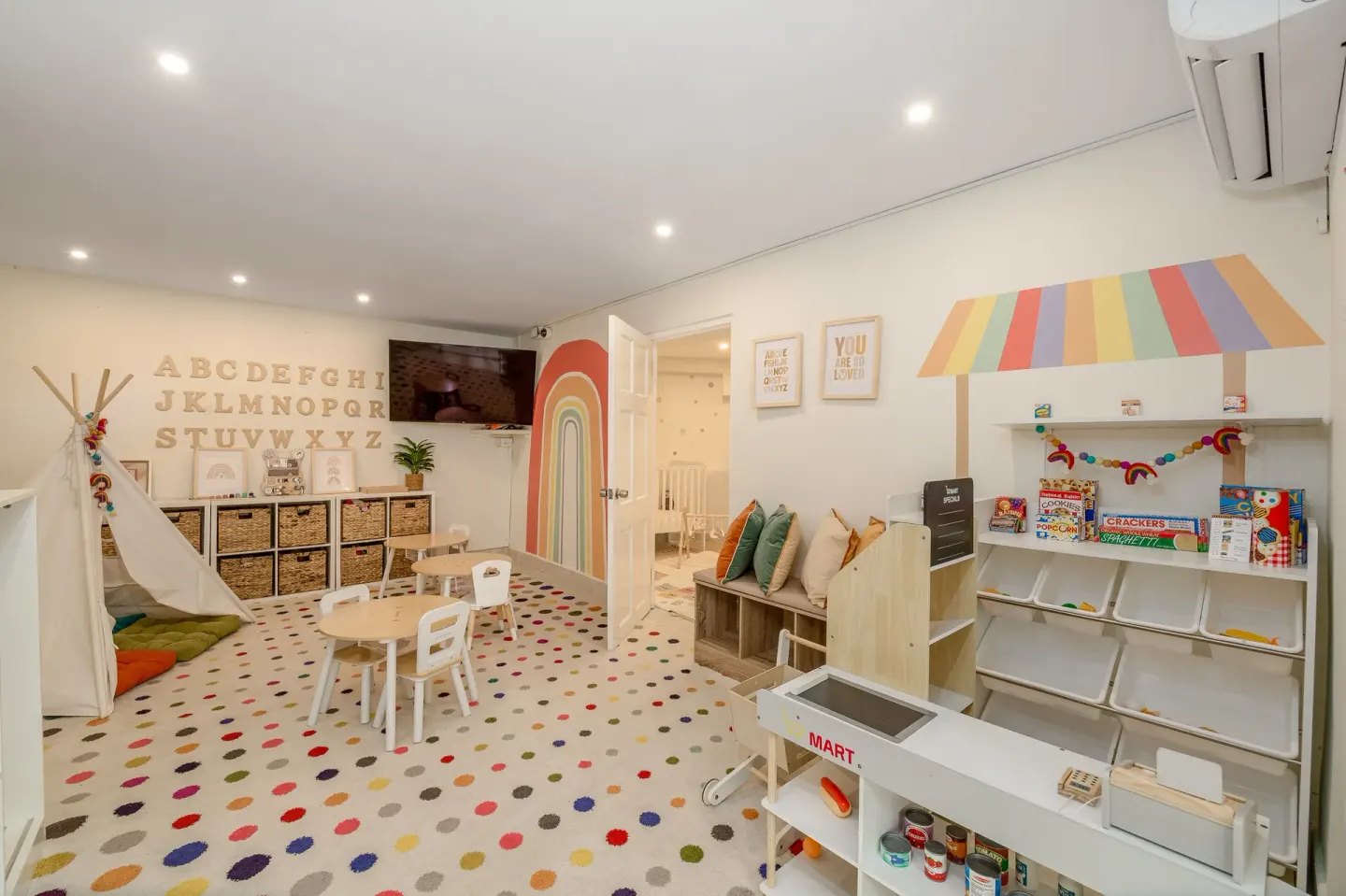 Bright children’s playroom with teepee, small tables and toy market at Sugar Bay Barbados.