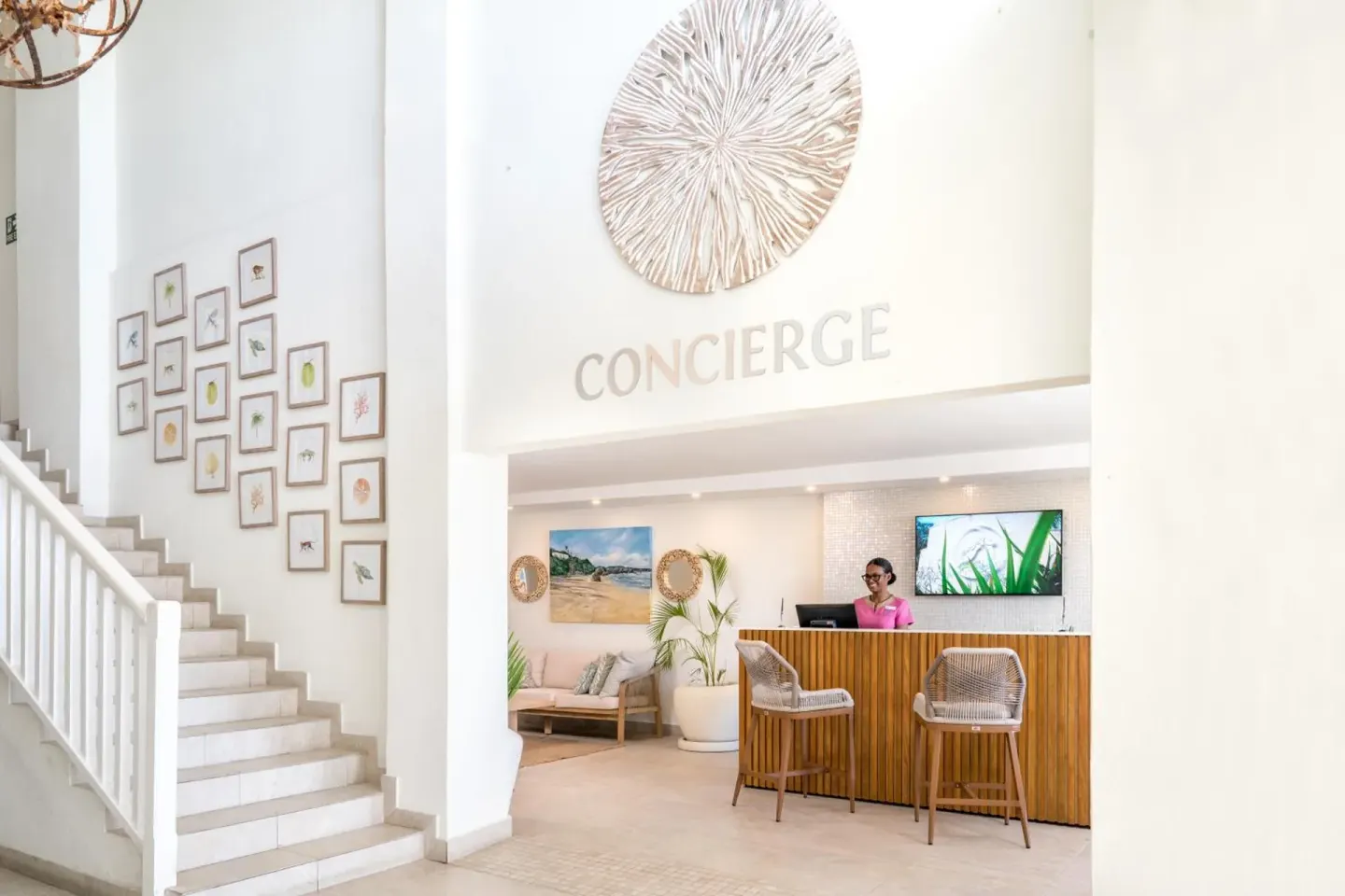 Concierge desk with staircase and wall art at Sugar Bay Barbados.