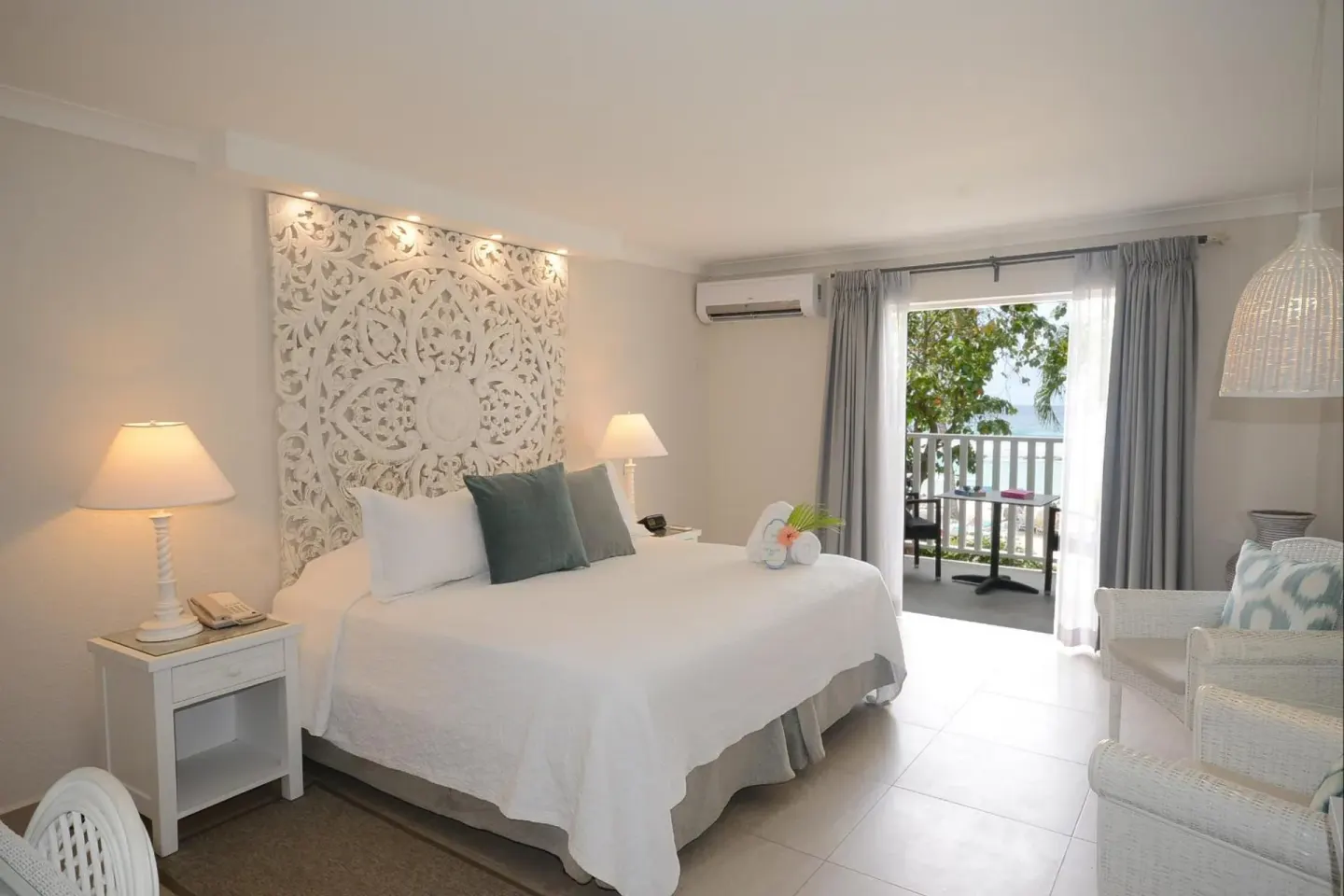 King bed guest room with balcony doors and seating at Sugar Bay Barbados.
