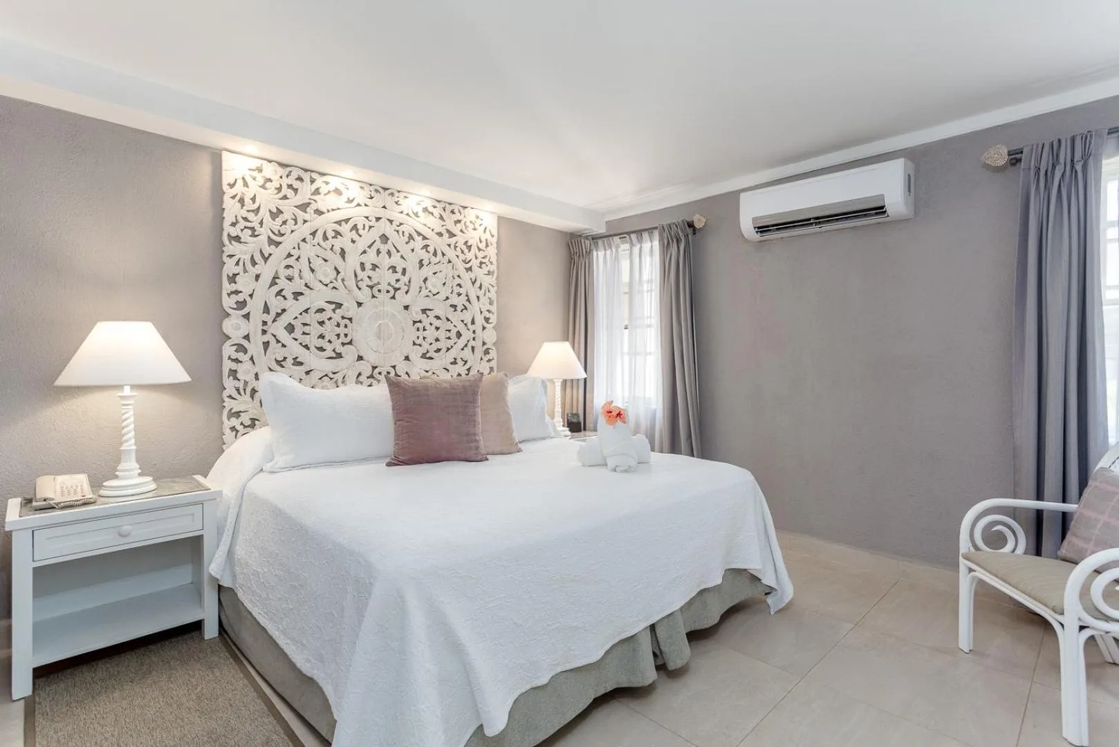Guest room with a king bed and carved headboard at Sugar Bay Barbados.