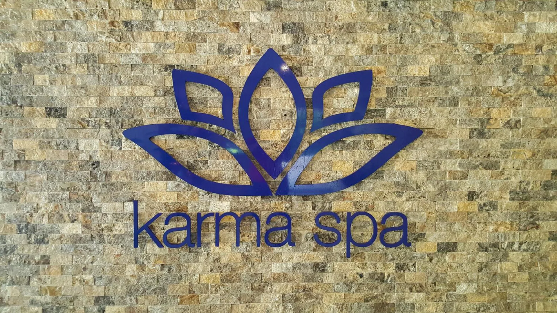 Karma Spa lotus sign on a stone wall at Sugar Bay Barbados.