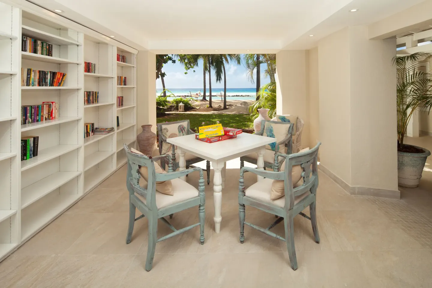 Library lounge with bookshelves, game table, and beach view at Sugar Bay Barbados.