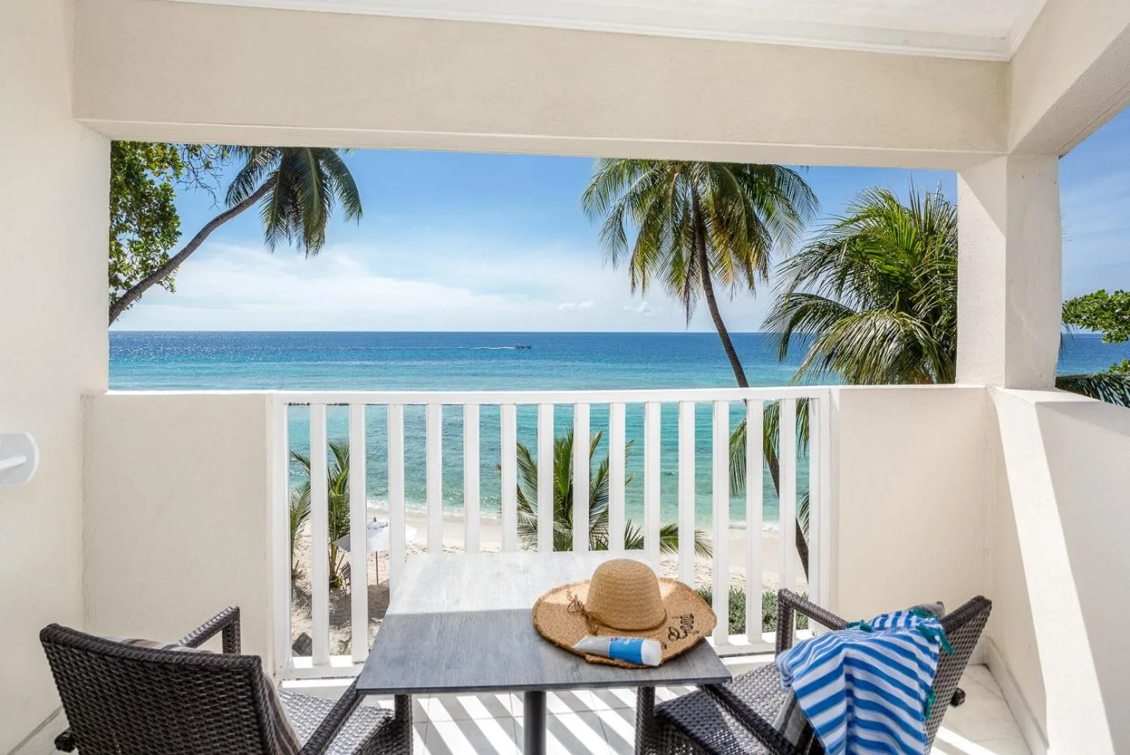 Balcony seating with ocean view and palm trees at Sugar Bay Barbados.