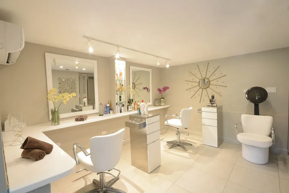 Salon room with styling chairs, mirrors, and product displays at Sugar Bay Barbados.