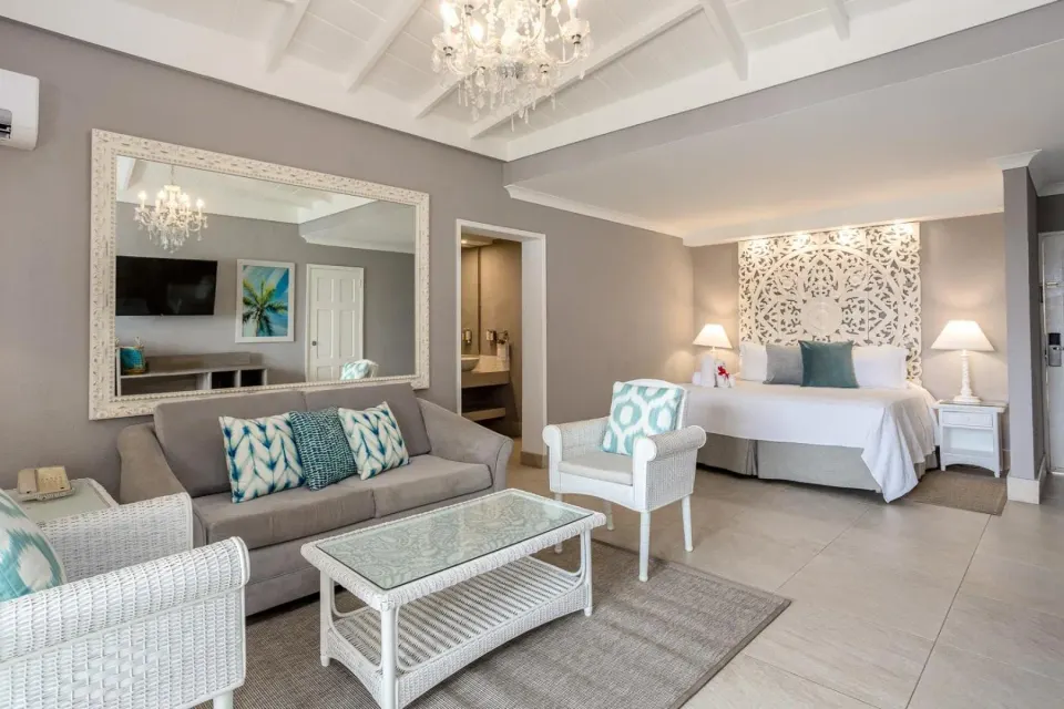 Deluxe Oceanfront Room with sofa, chairs, and bed at Sugar Bay Barbados.