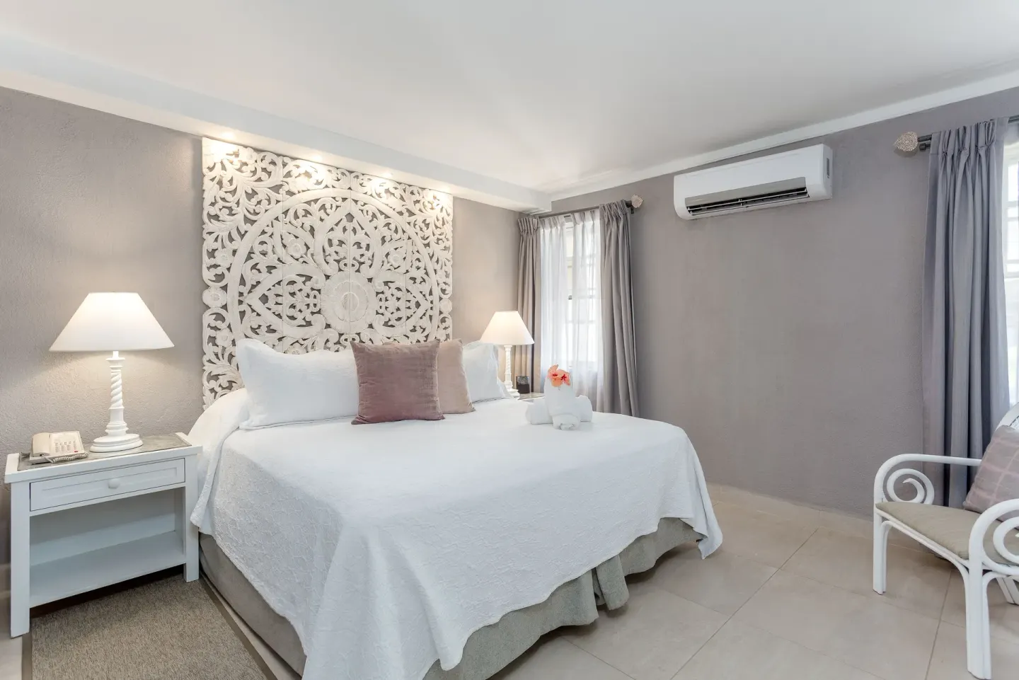Family Suite Garden View bedroom with king bed and carved headboard at Sugar Bay Barbados.
