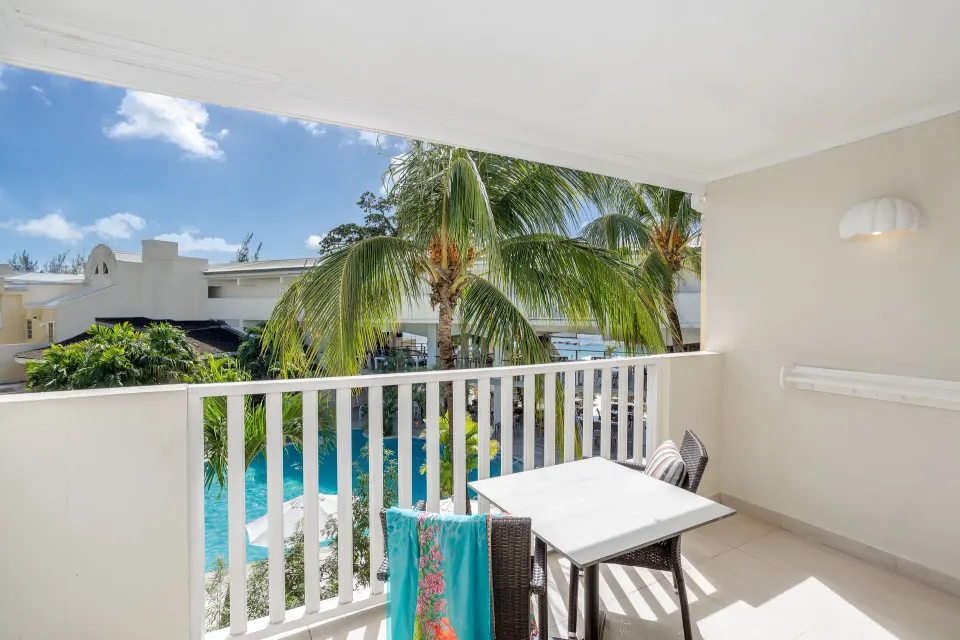 Signature Room Garden View balcony with table, chairs and palms at Sugar Bay Barbados.