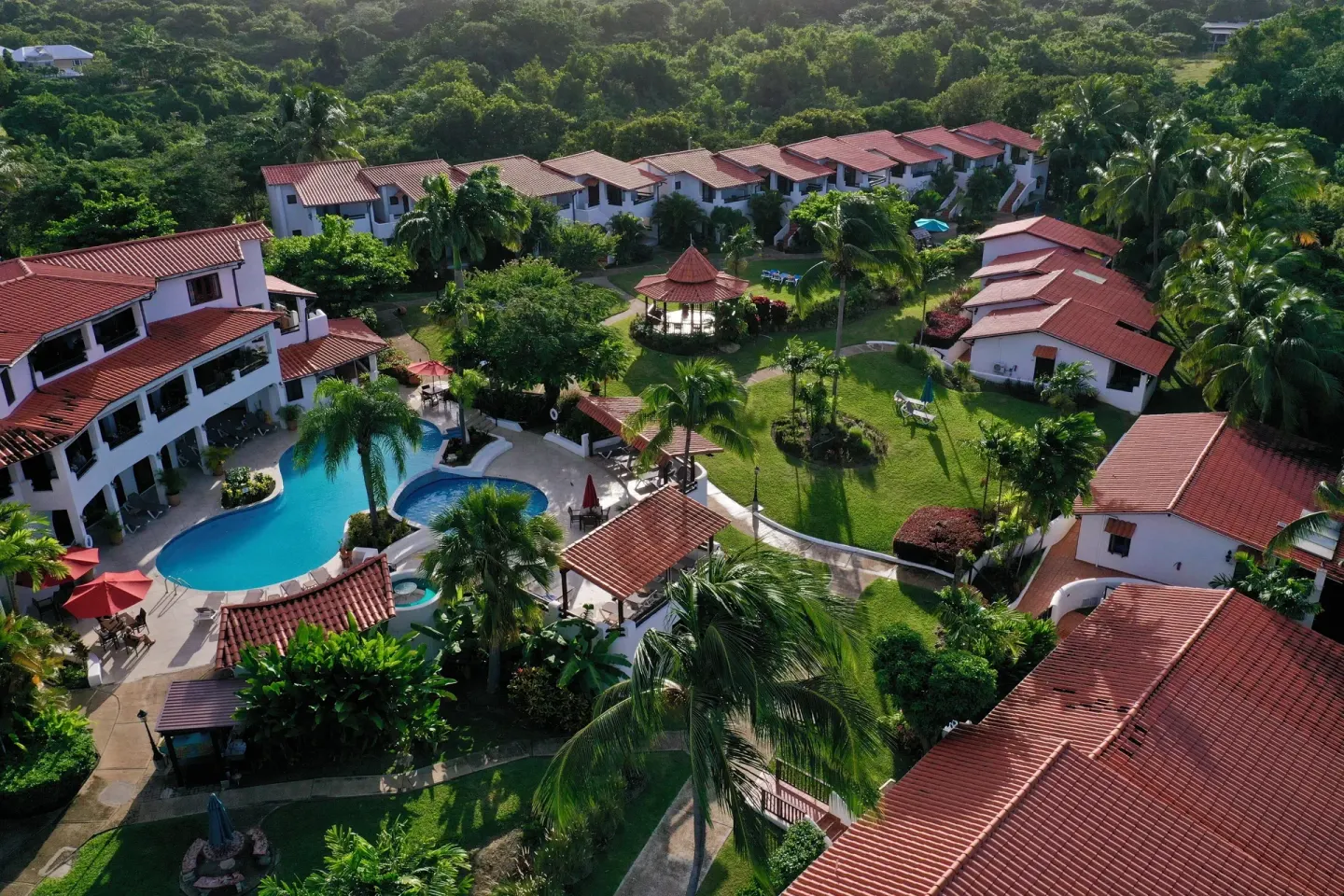 Aerial view of pool, gardens and red-roof buildings at Sugar Cane Club Hotel And Spa.