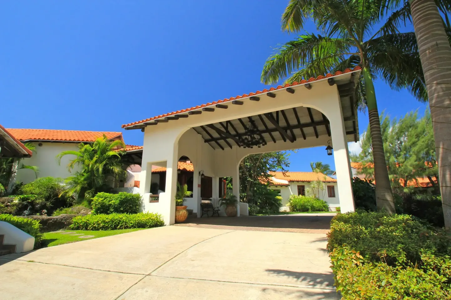 Arched resort entrance with red tile roof at Sugar Cane Club Hotel And Spa.