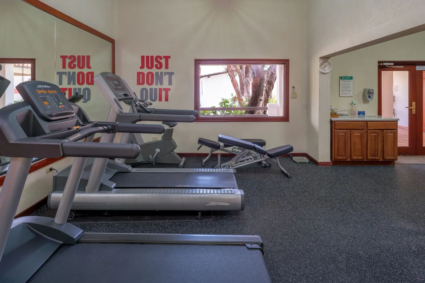 Treadmills and workout bench in the fitness room at Sugar Cane Club Hotel And Spa.