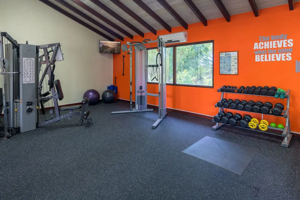 Weight machines and dumbbells in the gym at Sugar Cane Club Hotel And Spa.