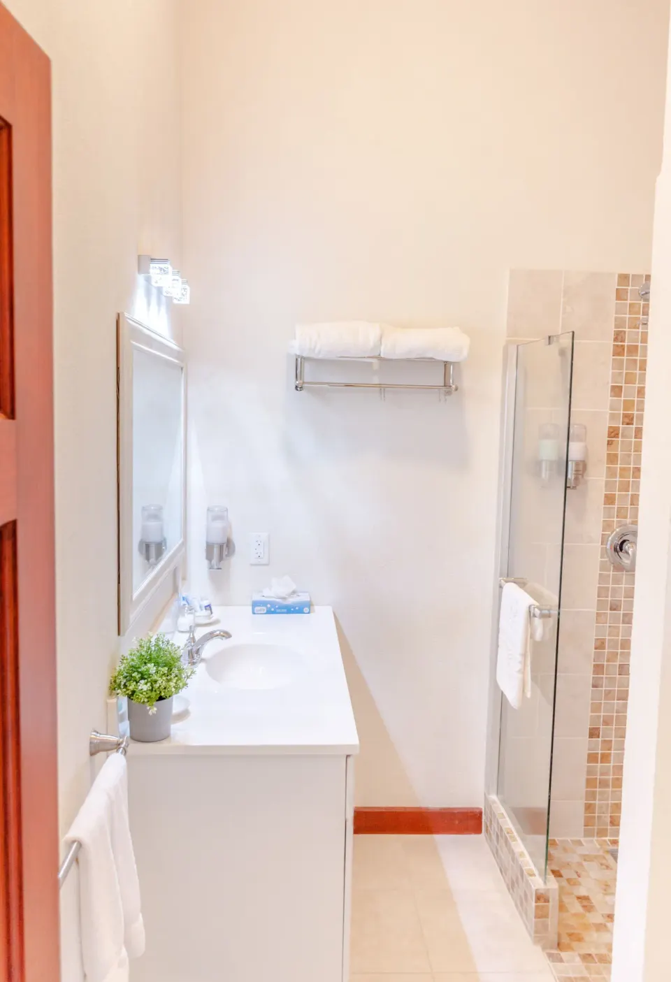 Garden View room bathroom vanity and shower at Sugar Cane Club Hotel And Spa.
