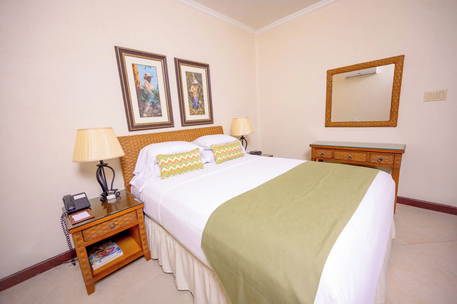 Garden View Suite bedroom with a large bed and wood dresser at Sugar Cane Club Hotel And Spa.