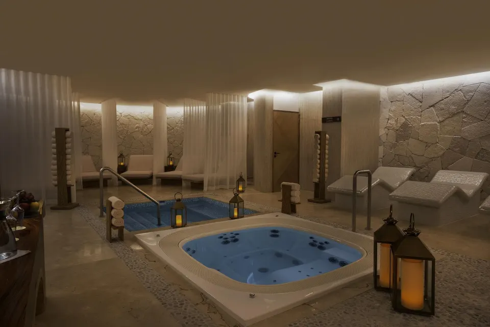 Spa hydrotherapy area with hot tubs, loungers, towels, and lanterns at Sun Palace Cancun.