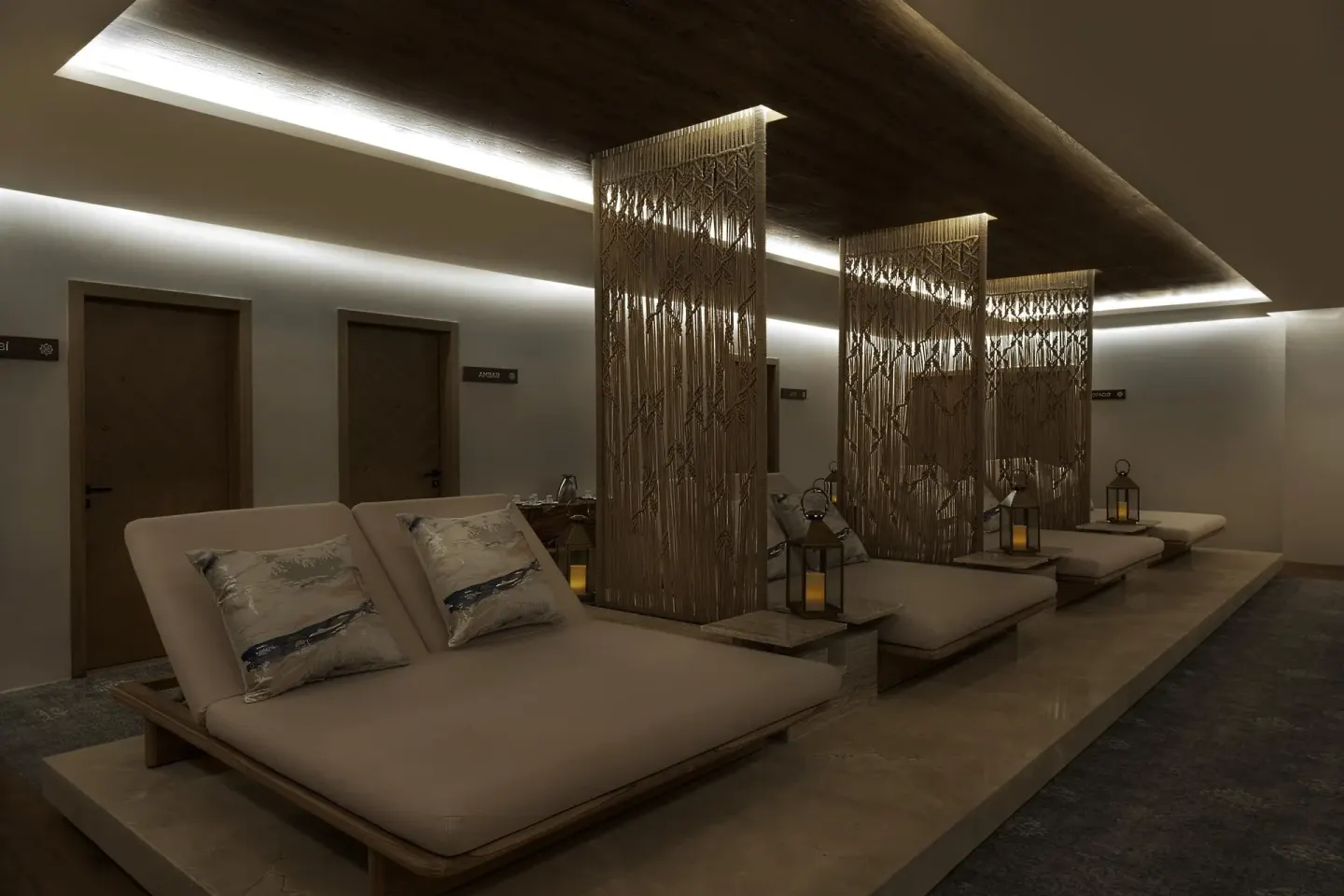 Spa relaxation lounge with cushioned daybeds and decorative screens at Sun Palace Cancun.