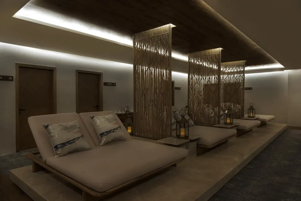 Spa relaxation lounge with cushioned daybeds and decorative screens at Sun Palace Cancun.