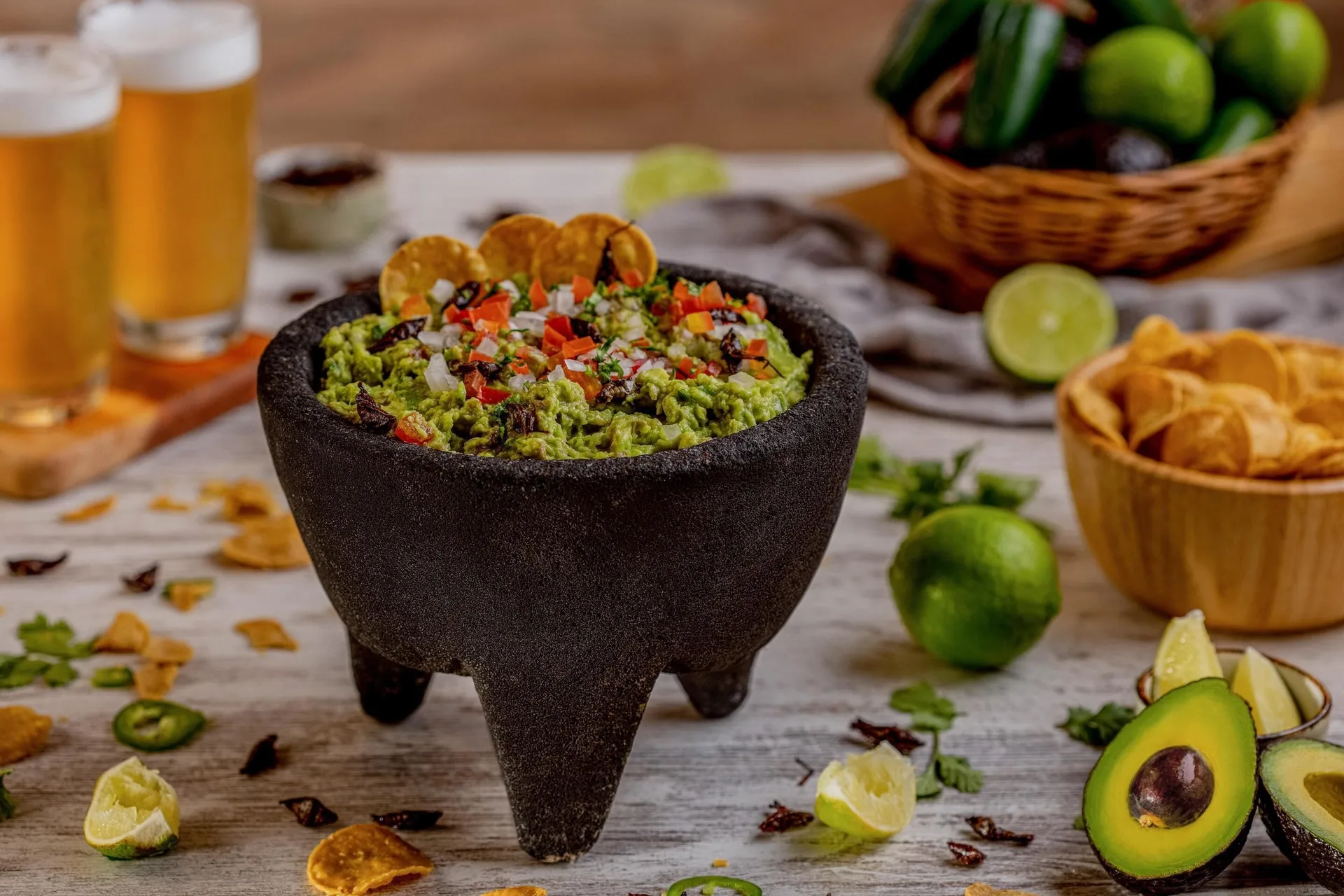 Guacamole in a stone bowl with chips, limes, avocados, and beers at Sun Palace Cancun.