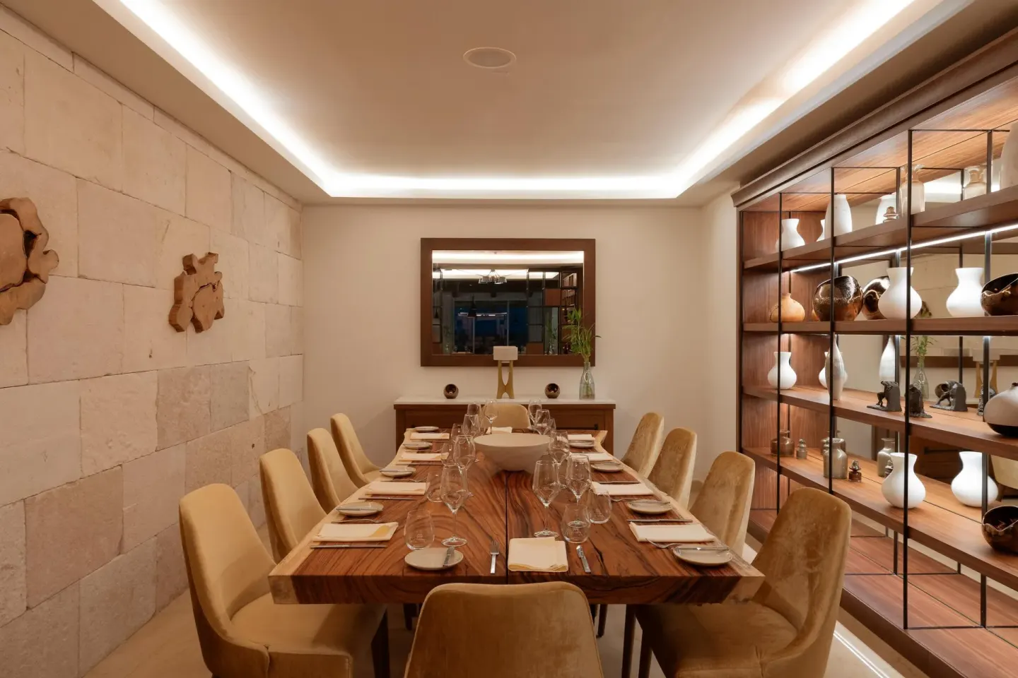 Private dining room with a long set table and display shelves at Sun Palace Cancun.