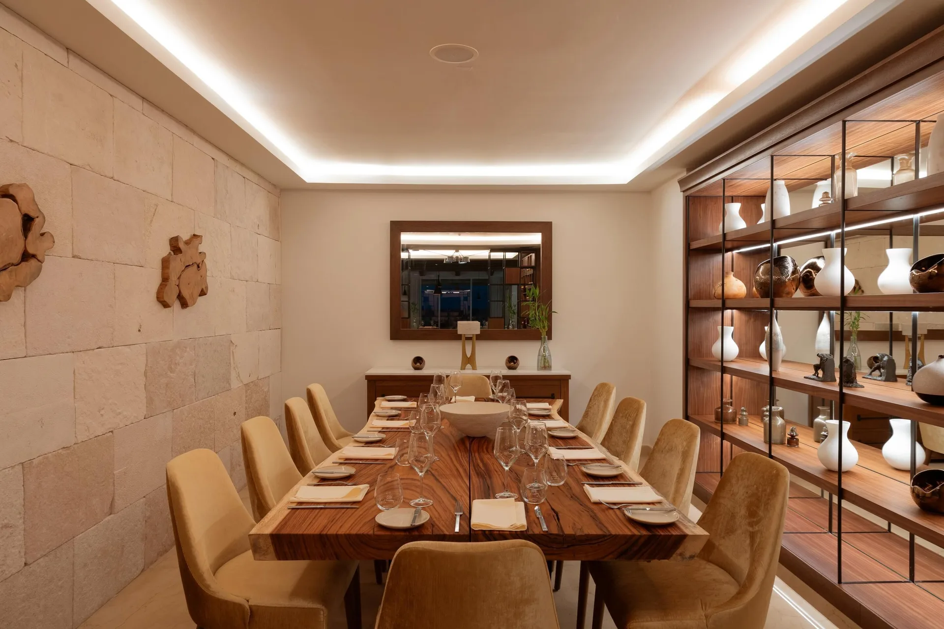 Private dining room with a long set table and display shelves at Sun Palace Cancun.