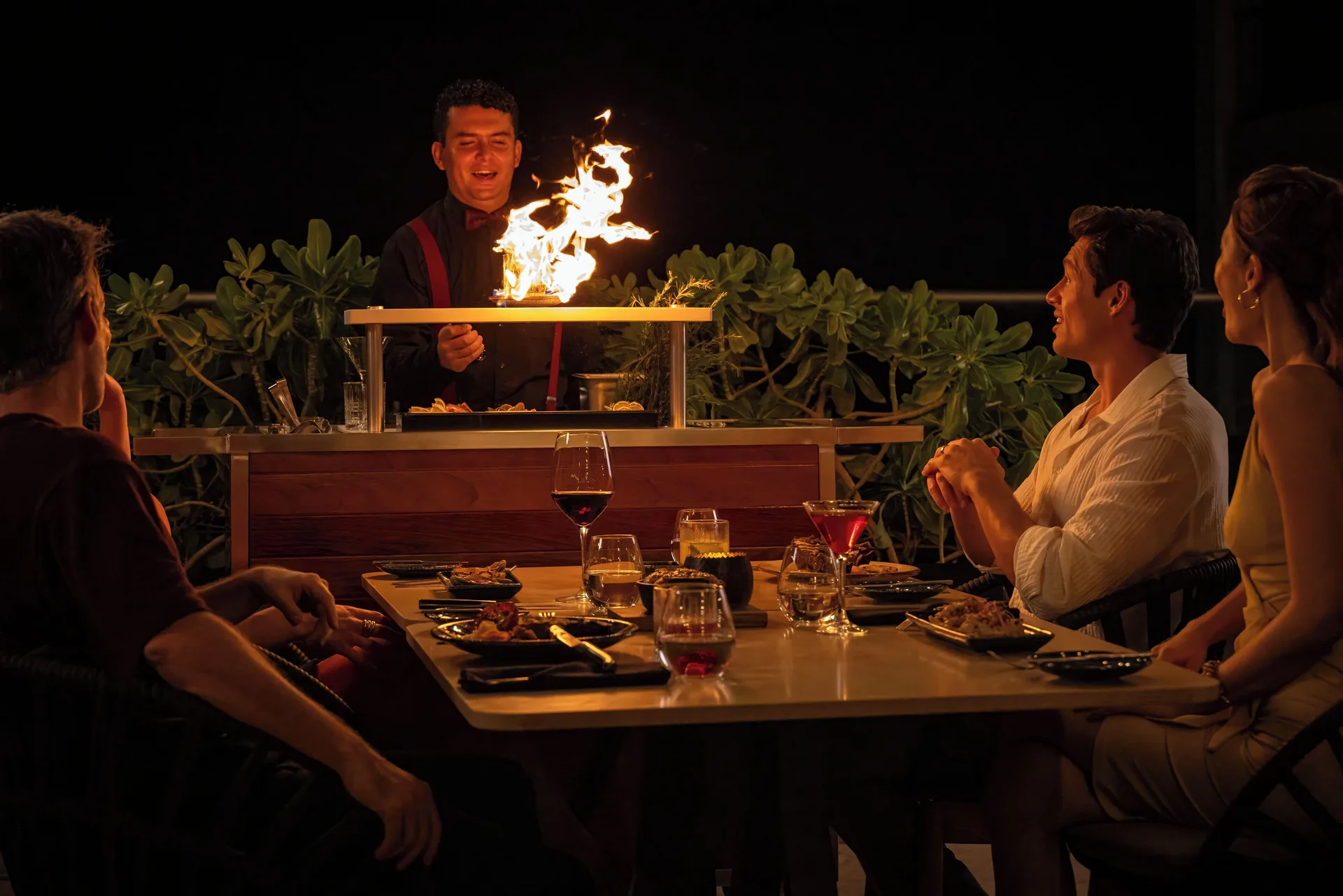Chef prepares a flaming tableside dish for diners at Sun Palace Cancun.