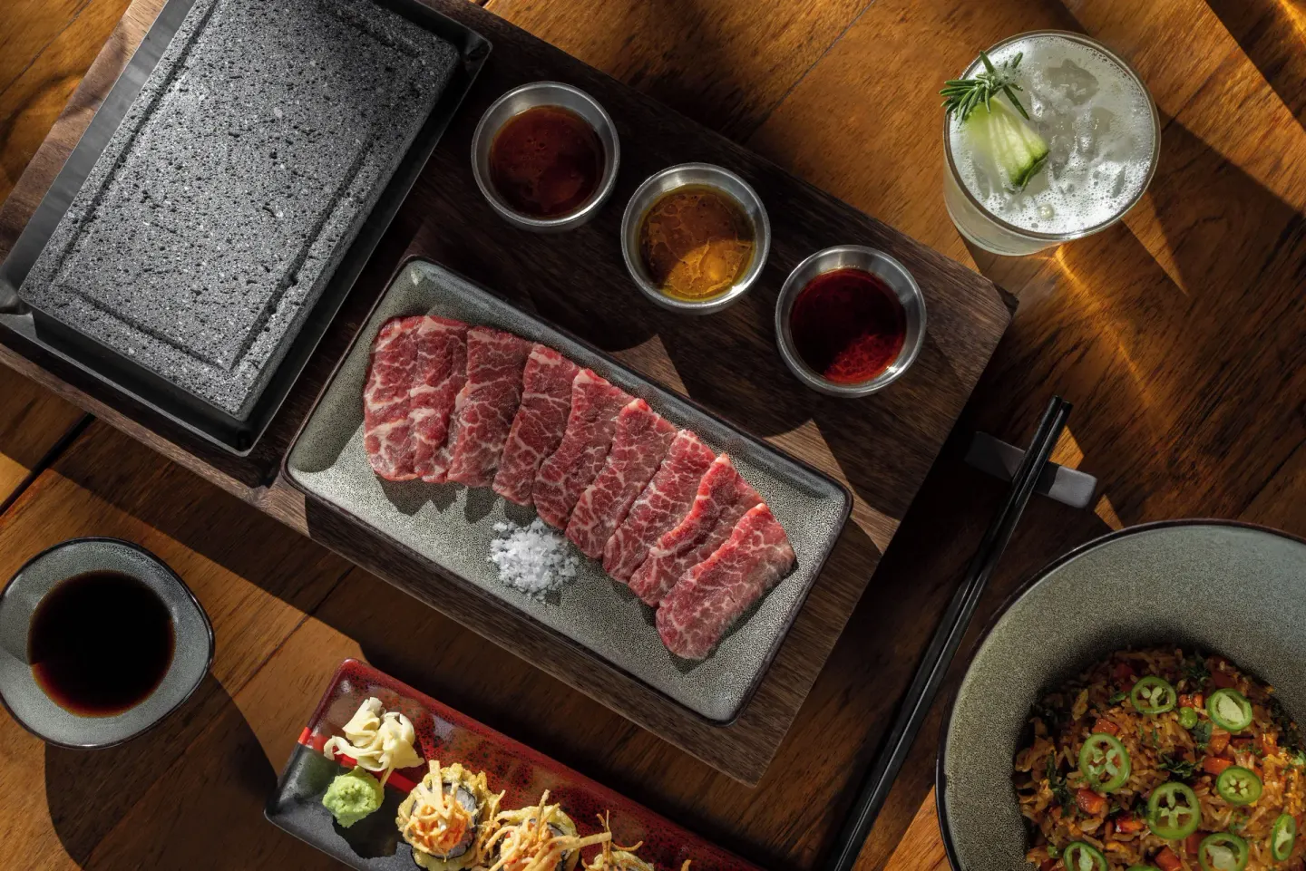 Sliced raw beef with sauces, hot stone, sushi, and cocktail at Sun Palace Cancun.