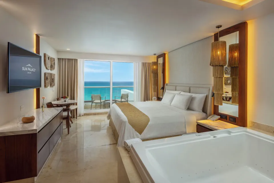 Superior Deluxe Ocean View king room at Sun Palace Cancun with tub, TV, and balcony.