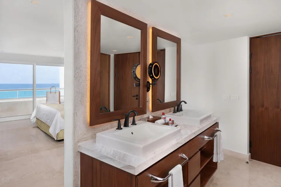 Superior Governor Suite bathroom vanity with dual sinks and bedroom view at Sun Palace Cancun.