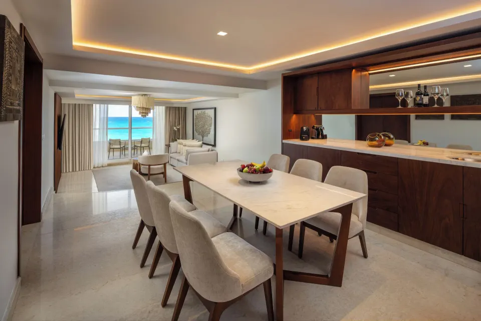 Superior Governor Suite dining table, wood bar, and lounge with ocean view at Sun Palace Cancun.