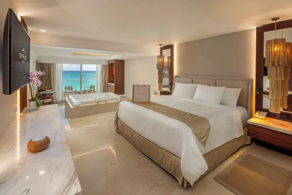 Superior Honeymoon Suite Ocean View king bed and ocean-facing windows at Sun Palace Cancun.
