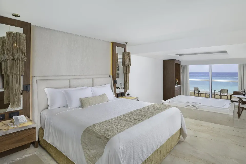 Superior Junior Suite Ocean View king bed, in-room tub, and balcony at Sun Palace Cancun.