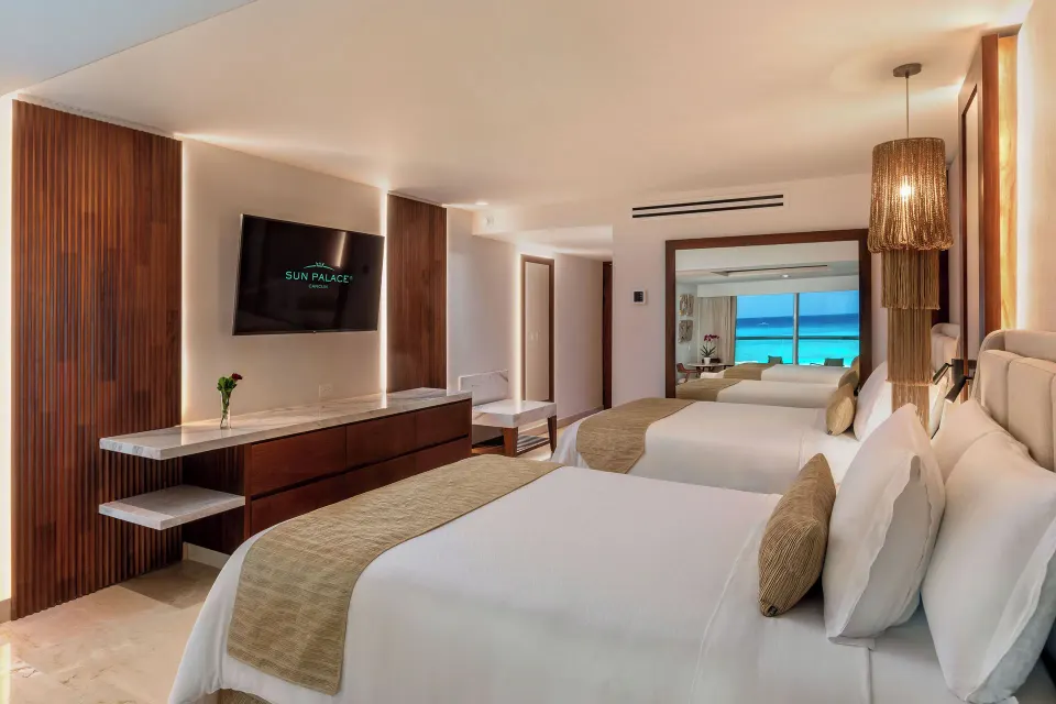 Superior Junior Suite Ocean View with two beds and turquoise sea beyond at Sun Palace Cancun.