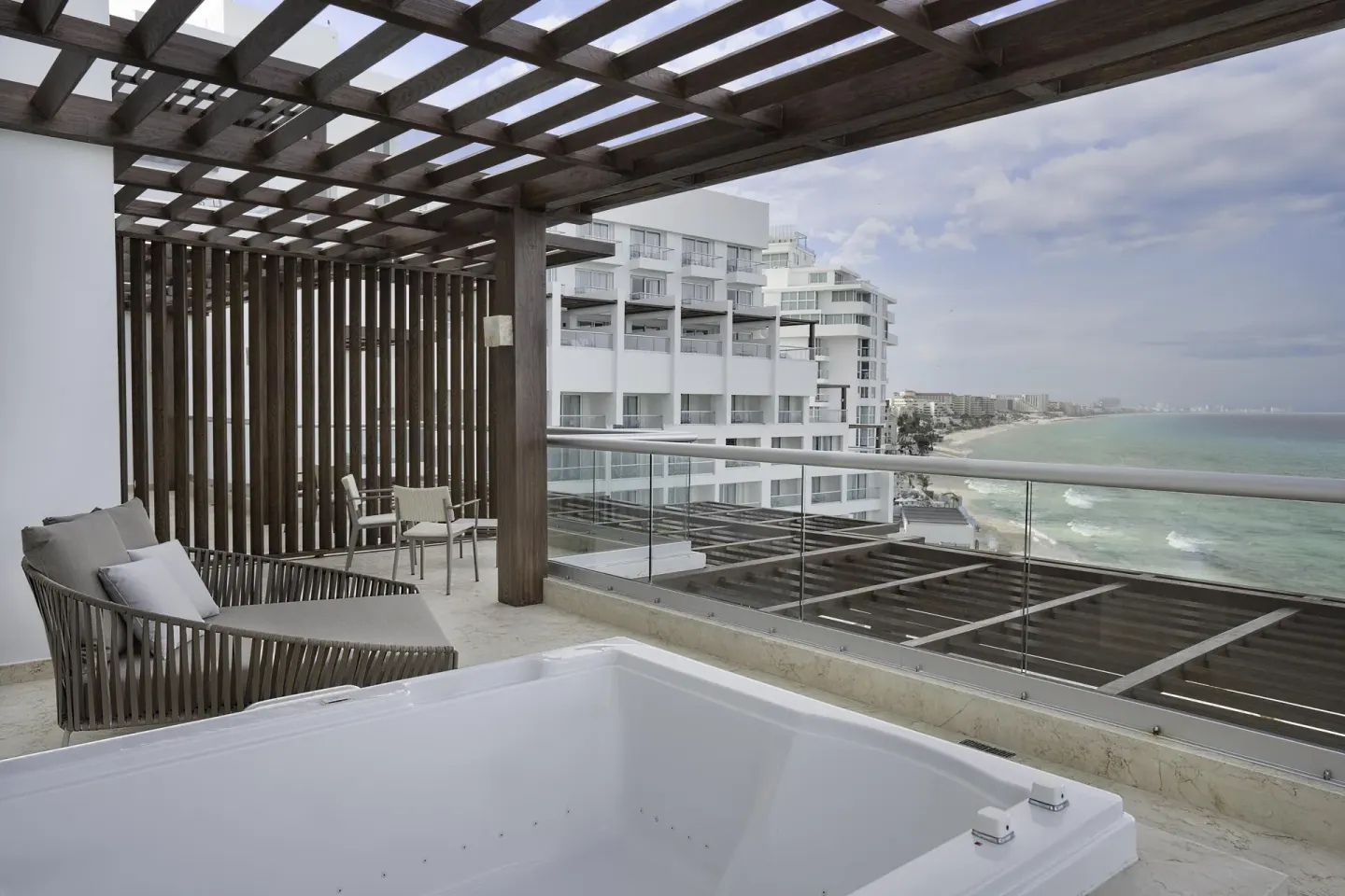 Covered suite terrace with plunge tub and coastline view at Sun Palace Cancun.