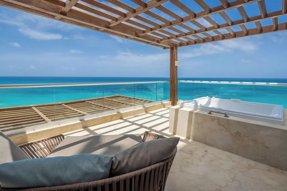 Oceanfront terrace with lounge seating and soaking tub at Sun Palace Cancun.