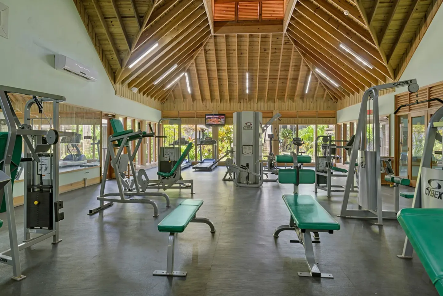 Fitness center with benches, machines, and high wood ceiling at Sunset at the Palms Resort.