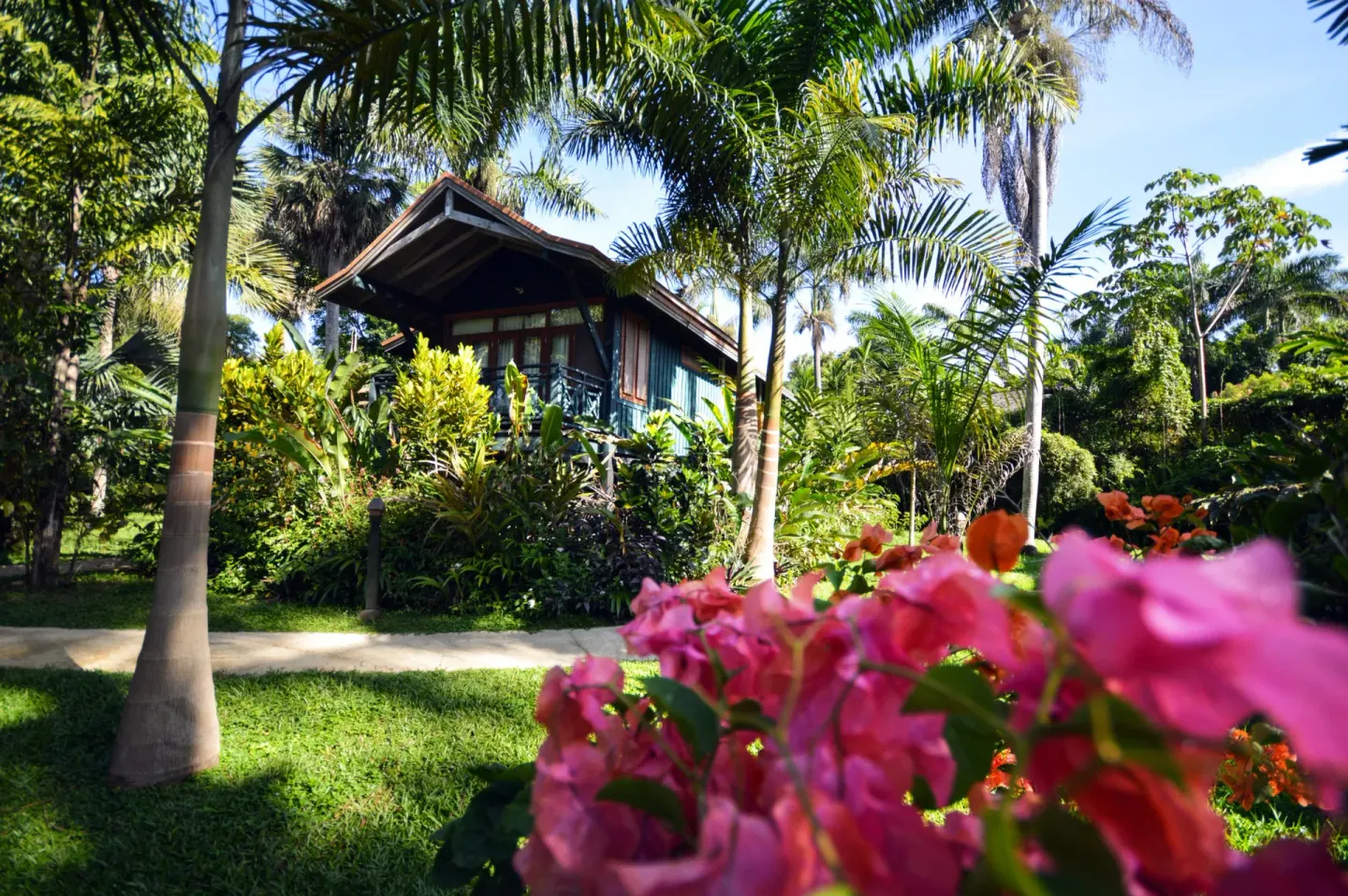 Garden bungalow framed by palms and flowers at Sunset at the Palms Resort.