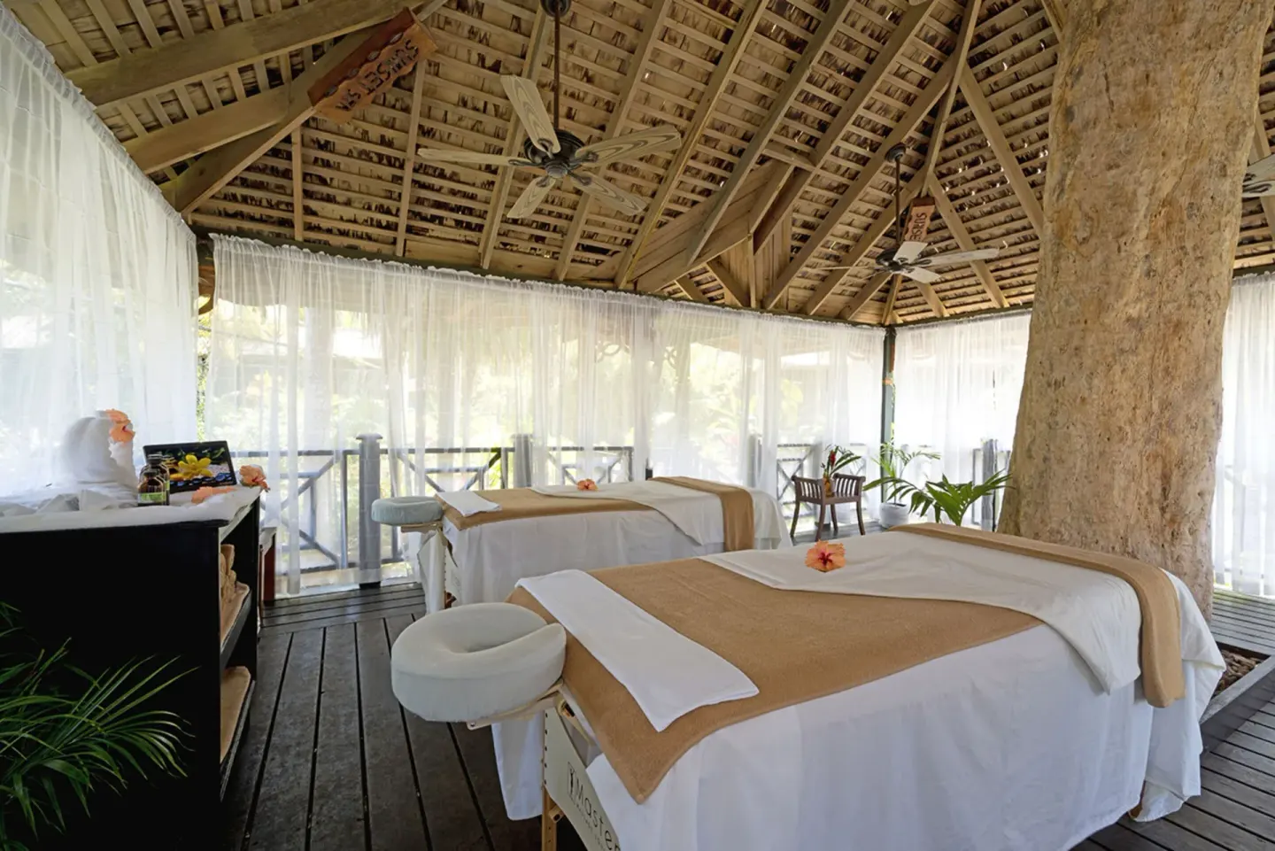 Open-air spa treatment room with two massage tables at Sunset at the Palms Resort.