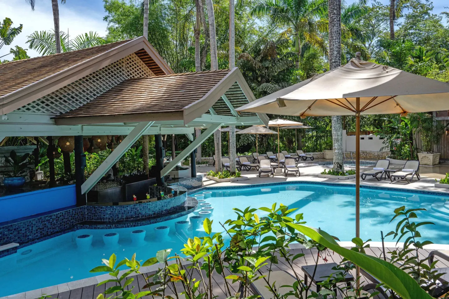 Poolside loungers, umbrellas, and swim-up bar at Sunset at the Palms Resort.