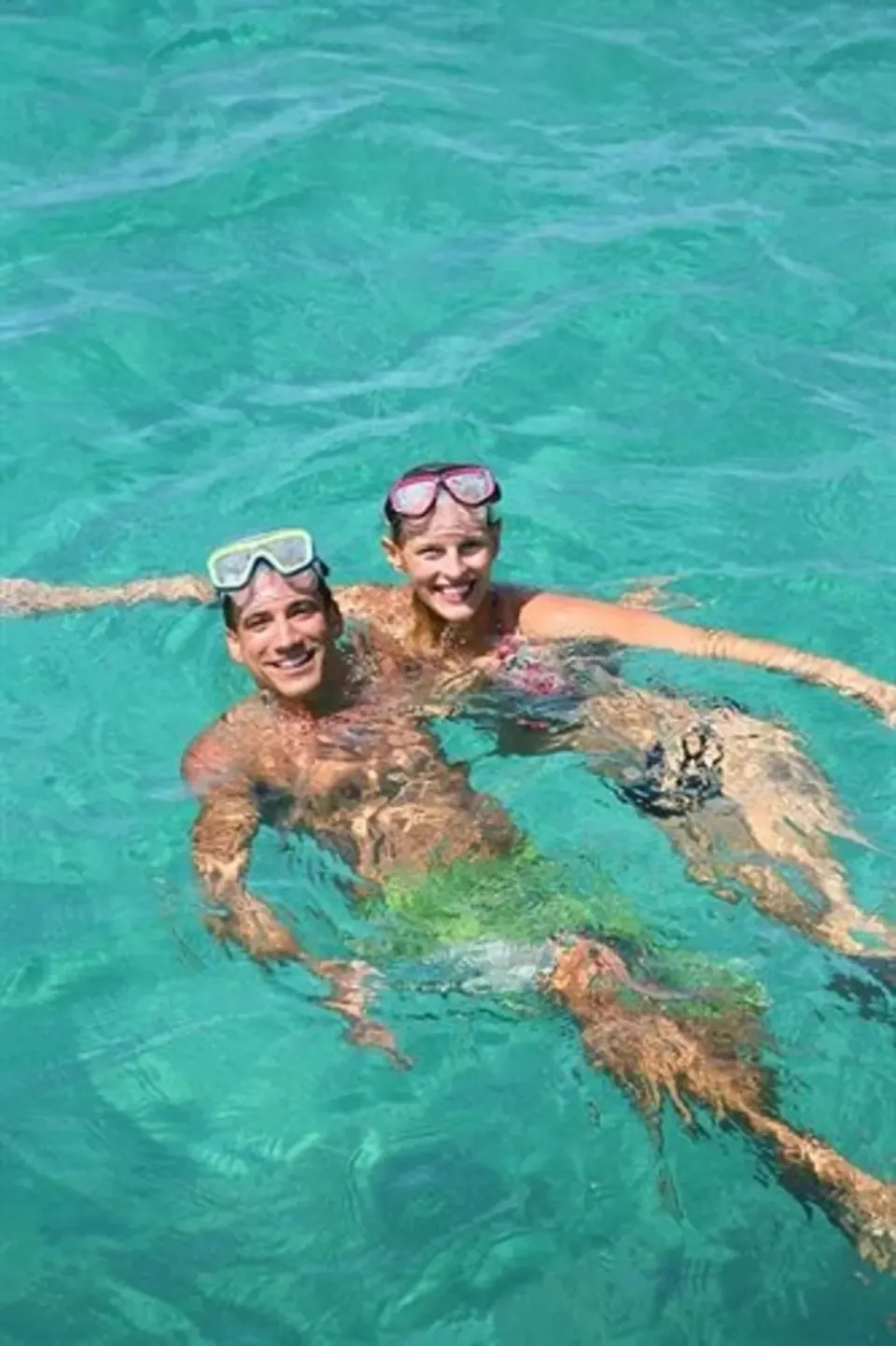 Two guests float with snorkel masks in clear turquoise water at Sunset at the Palms Resort.