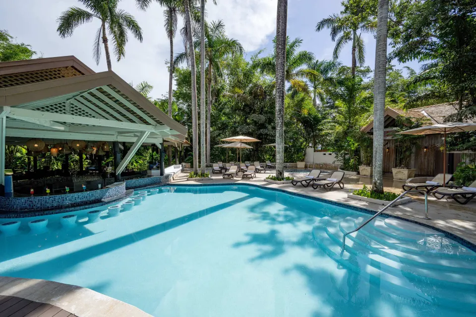 Swimming pool with swim-up bar and palm trees at Sunset at the Palms Resort.