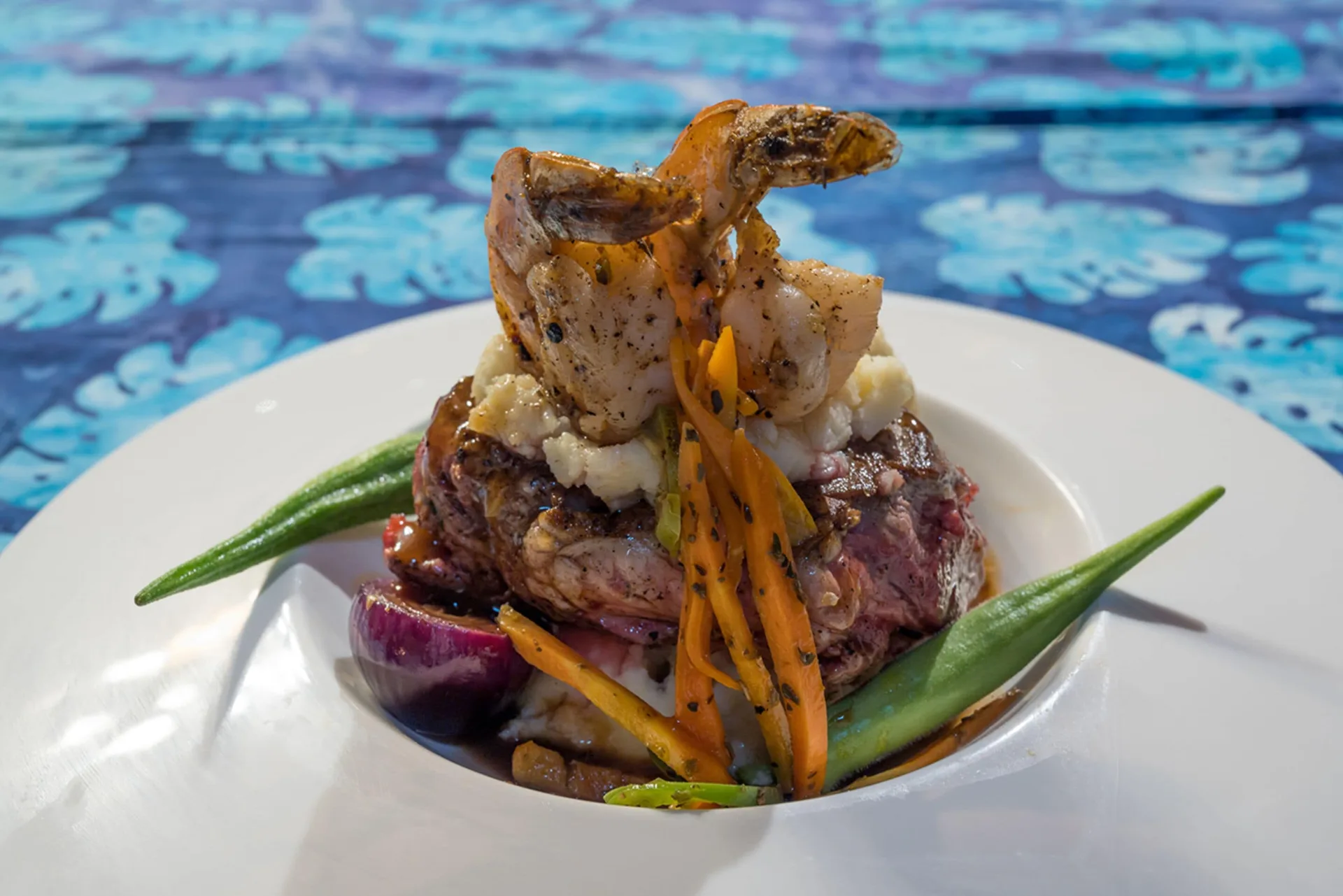 Plated entree with shrimp and vegetables at Sunset at the Palms Resort.