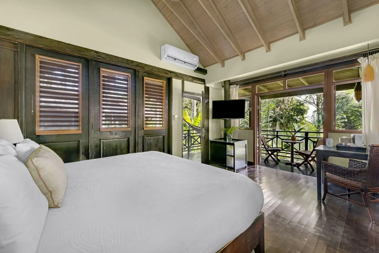 Treetop Deluxe king bed and balcony seating at Sunset at the Palms Resort.