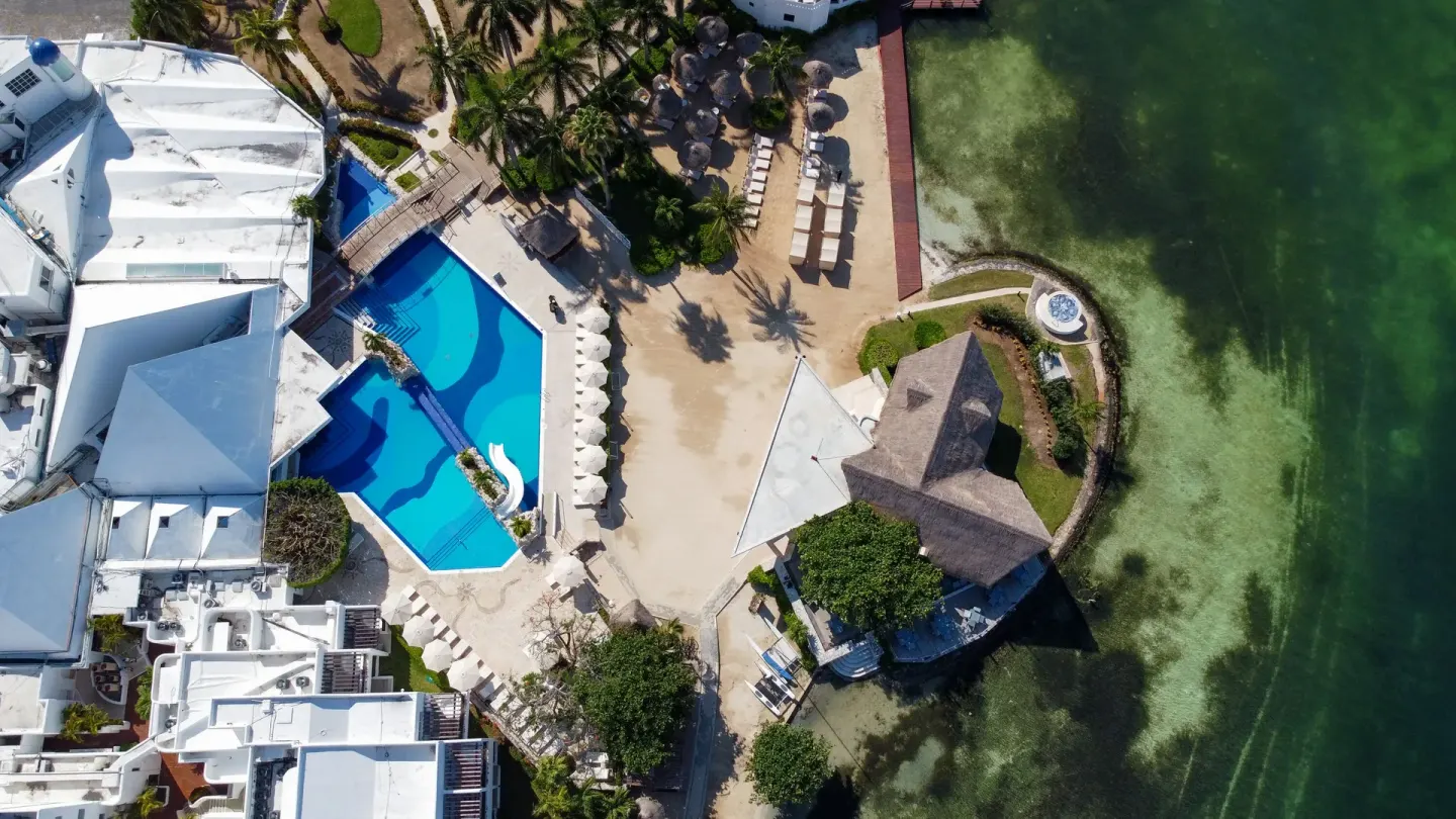 Aerial view of pool, shoreline and palms at Sunset Marina Resort & Yacht Club.