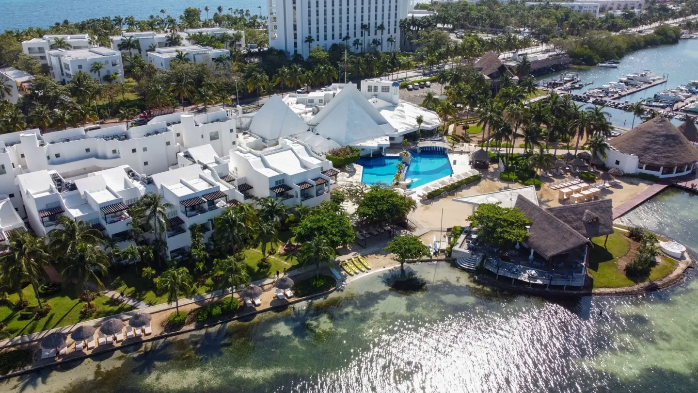 Aerial shoreline view of Sunset Marina Resort & Yacht Club with pools, palapas, and marina.