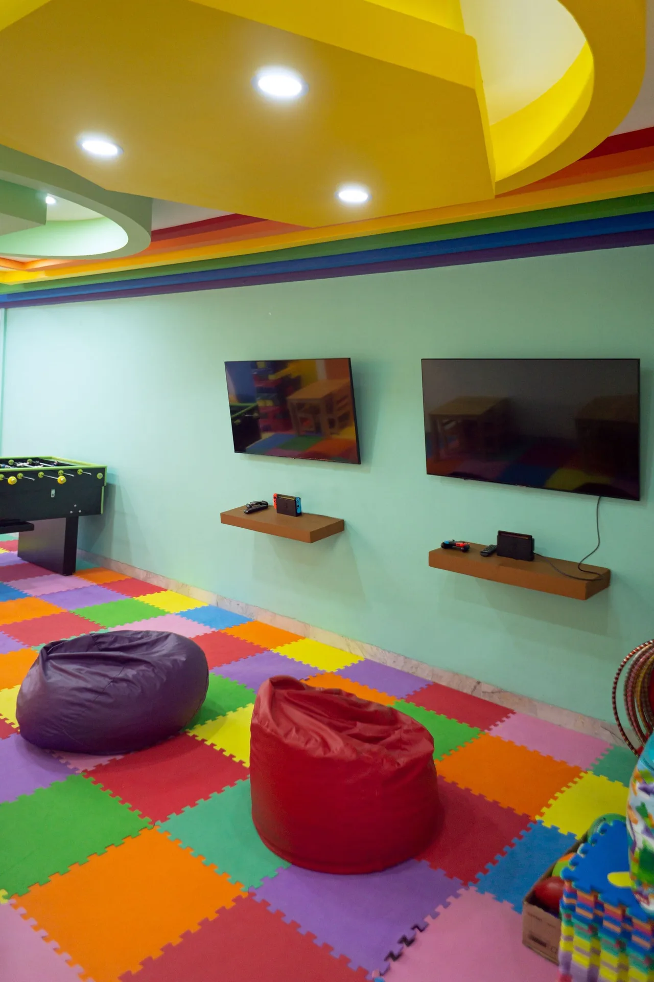 Game room with screens, beanbag seating, and colorful flooring at Sunset Marina Resort & Yacht Club.