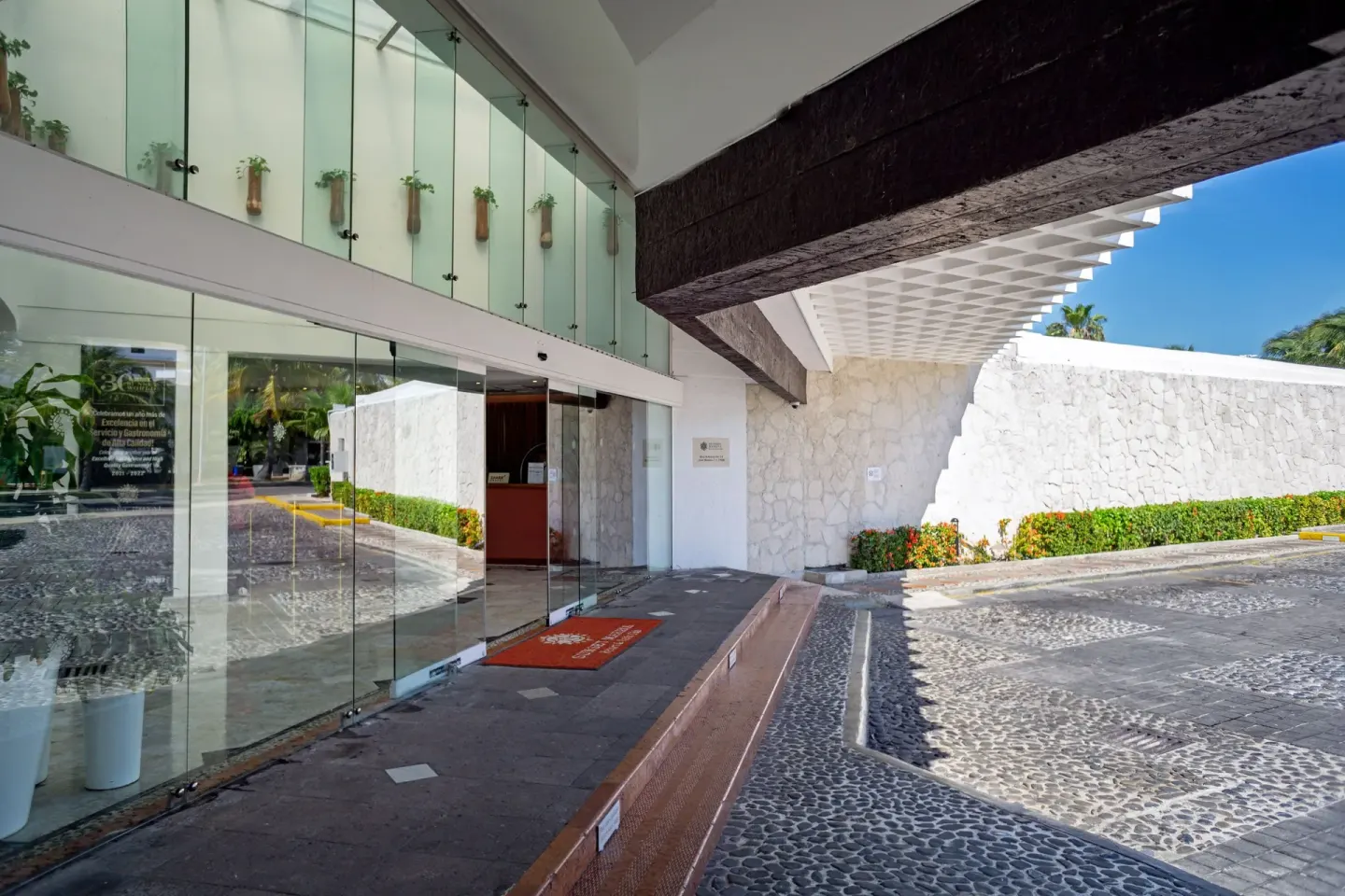 Glass-fronted entrance and cobblestone drive at Sunset Marina Resort & Yacht Club.