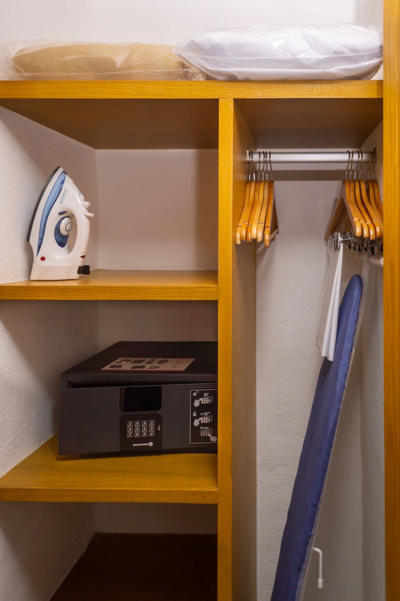 In-room closet with safe, iron, hangers, and ironing board at Sunset Marina Resort & Yacht Club.