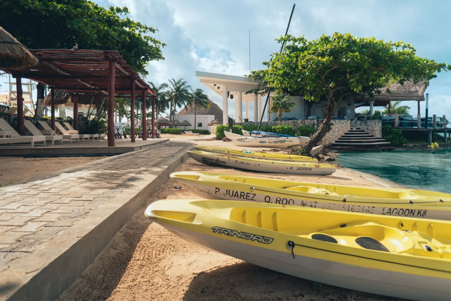 Kayaks lined on the sandy lagoon shore at Sunset Marina Resort & Yacht Club.